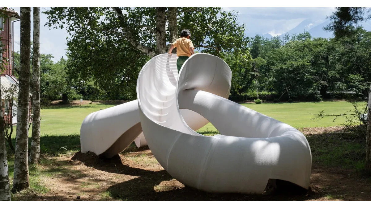 White Loop, un tobogán impreso en 3D inspirado en la cinta de Möbius, diseñado para el juego libre y la exploración en Kiyoharu Art Village, Japón.