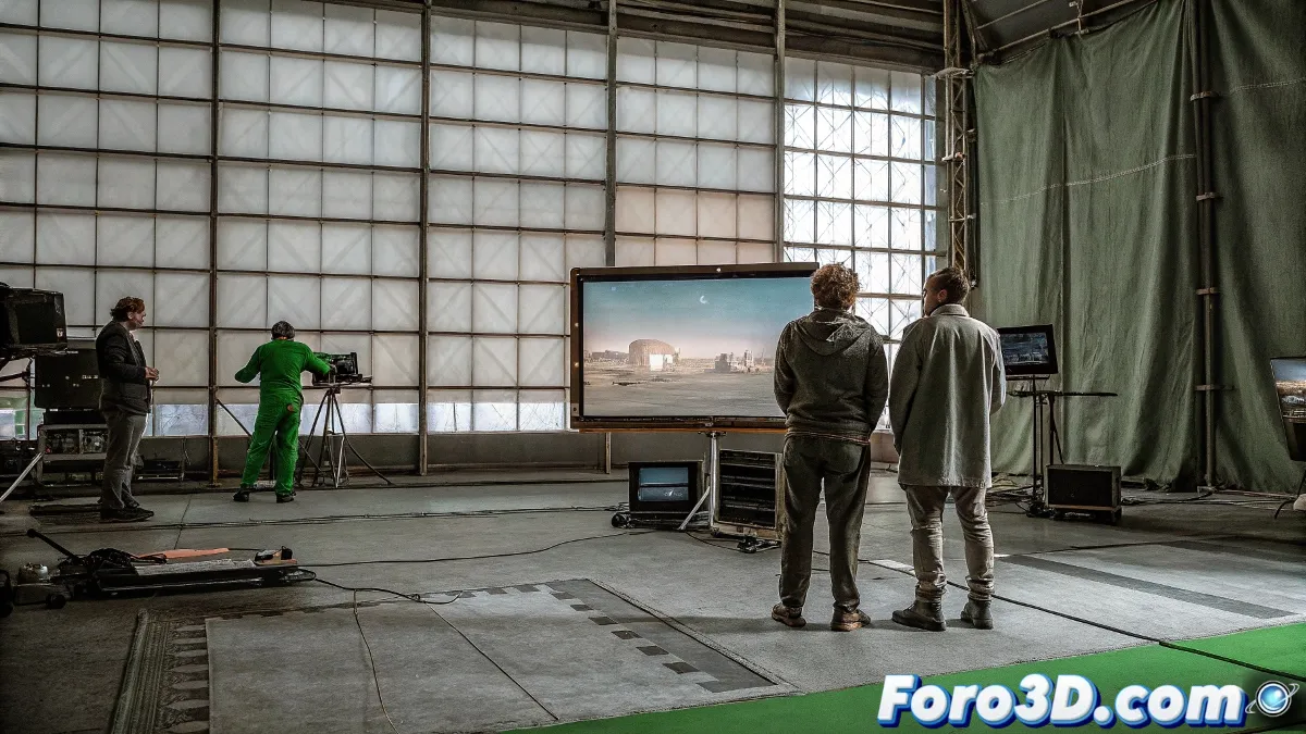 Una escena digital que represente una mezcla entre un set de rodaje real y un entorno completamente generado por ordenador, con actores rodeados de pantallas verdes y técnicos trabajando con ordenadores.