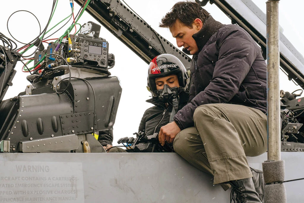 Fotografía de plató cinematográfico mostrando actores frente a pantalla verde mientras técnicos operan equipos de filmación y monitores muestran previzualizaciones con IA.